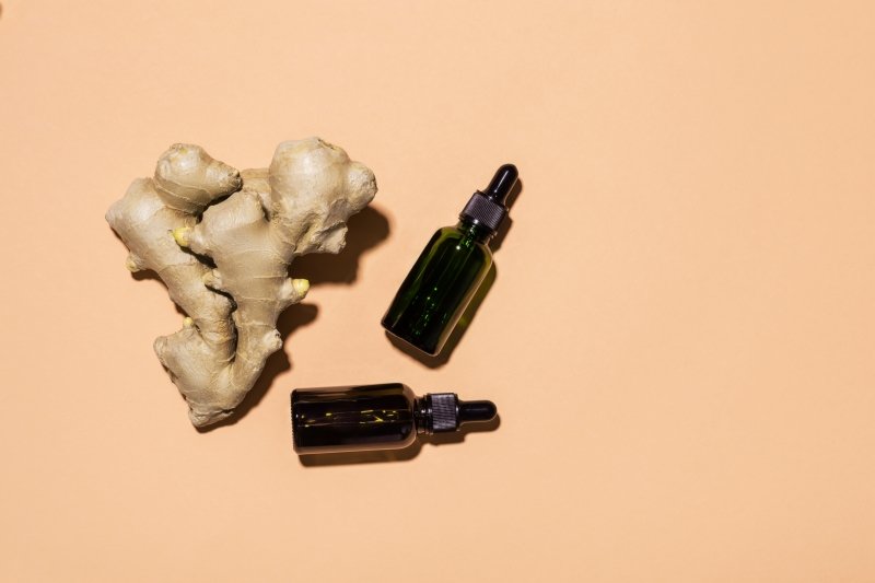 Ginger root next to bottles. Skincare concept.
